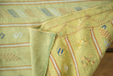 Fine weave of a lime green Moroccan Kilim, showcasing embroidered geometric motifs.