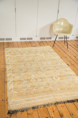 Dark saffron-y gold Moroccan Kilim rug with geometric patterns and dark fringed ends.