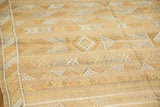 Detail of Moroccan Kilim rug's flatweave texture with saffron gold and off-white geometric patterns.