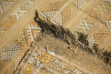 Woven fringe and textured reverse of a saffron-y gold Moroccan Kilim rug.