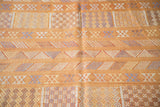 Burnt orange embroidered Moroccan kilim with varied geometric patterns in faded blue, ivory.
