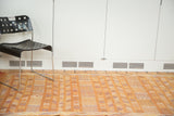 Moroccan kilim rug with wide burnt orange stripes and geometric designs.