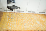 Saffron yellow Moroccan kilim rug featuring geometric stripes, floral guls, and serpent motifs.