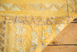 Moroccan kilim corner: saffron yellow, embroidered geometric patterns in mint, ivory, beige.