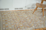 Geometric floral guls in eggplant, gold, and ivory on a striped Moroccan Kilim.