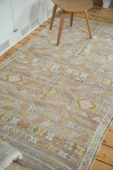 Embroidered stripes with geometric and serpent motifs on a subtle eggplant purple kilim rug.