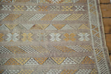Moroccan Kilim rug with finely woven serpent motifs, geometric guls, and stripes in eggplant, ivory, gold.