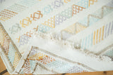 Finely woven Moroccan kilim rug corner with white fringe and embroidered geometric patterns in pastels.