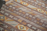 Detailed view of deep eggplant embroidered kilim with geometric guls and striped patterns.