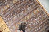 Moroccan New Kilim rug with deep eggplant, gold, ivory, silver geometric striped patterns.
