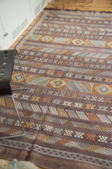 Detailed embroidered stripes with geometric guls and serpent motifs on the deep eggplant kilim.