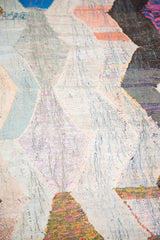 Close-up of vintage rag rug showing its mixed light and dark argyle diamonds.