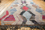 Textured fringe and colorful argyle diamond pattern on vintage Moroccan rag rug.