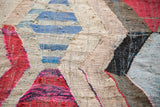 Detail of the vintage Moroccan rag rug's hand-woven texture with colorful argyle diamonds.