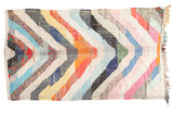 Colorful vintage rag rug with diagonal stripes in tangerine, blue, red, ivory, grey, and pink.