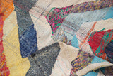 Vibrant interwoven recycled textile strips in a vintage rag rug.