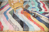 View of a vibrant vintage Moroccan rag rug, wide diagonal stripes, varied colorful texture.