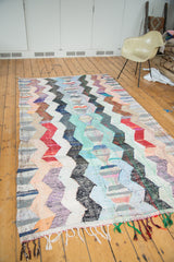Running zigzag motif in peach, mint, denim blue, and red on vintage rag rug.