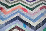 Vintage rag rug with distinct zigzag pattern and colorful woven recycled cotton texture.