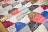 Hexagonal geometric pattern on vintage Moroccan rag rug with varied vibrant textile strips.