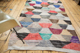 Dense woven texture of the Moroccan rag rug's colorful hexagonal pattern.