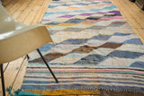 Vintage rag rug end with horizontal stripes in mixed blue, yellow, and purple recycled textiles.