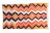Vintage rag rug with zig-zag chevron and diamond pattern. Faded tangerine, red, black, off-white.