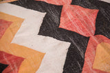 Vintage Moroccan rag rug with zig-zag pattern in off-white, faded orange, brick red, charcoal.