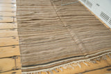 Textured flatweave of vintage Moroccan Kilim rug featuring rhythmic beige and brown stripes, with fringe.