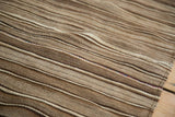 Striated brown and beige flatweave texture on a vintage Moroccan Kilim, with tiny colorful accents.