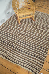 Striated natural ivory, coffee, and charcoal black stripes of a vintage Moroccan Kilim with lime green overcast.