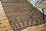 Vintage Moroccan Kilim rug showing striated weaving in brown, ivory, and subtle green tones with fringe.