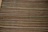 Close-up of Moroccan Kilim's wool flatweave, showing natural brown, beige, and green stripes.