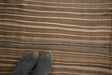 Vintage Moroccan Kilim rug with textured brown, ivory stripes, and zig-zag line.