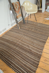 Vintage Moroccan Kilim rug with striated bands of natural brown, coffee, beige, and blue tones.