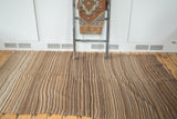 Vintage Moroccan Kilim flatweave rug with striated brown, ivory, and grey stripes and knotted fringe.