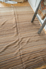 Vintage Moroccan Kilim rug showing variegated natural tone stripes and lime green, navy blue end.