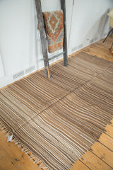 Knotted fringe and natural undyed striped pattern of a vintage Moroccan Kilim.