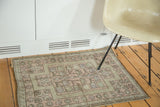Geometric germinating flowers and starburst pattern on a vintage Oushak rug in blush, mauve, and soft blue.