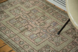 Vintage Oushak rug with geometric starburst and flower patterns in blush and soft green.