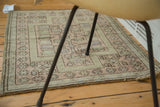 Vintage Oushak mat with geometric germinating flower motifs in dusty blush and beige.