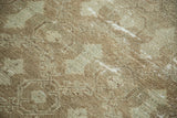 Faded celadon and natural brown shadow design, highlighting distressed texture on a vintage Oushak rug.