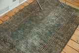 Textural distressed Persian Malayer rug with muted green field and meandering vine border.