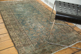 Heavily distressed vintage Malayer rug, revealing muted forest green tones and faded Herati pattern.