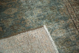 Folded corner of vintage distressed Malayer rug shows faded herati pile and hand-knotted foundation.