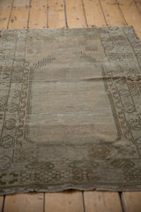 Vintage Oushak prayer rug with distressed texture, faded bronze hues, and exposed foundation.