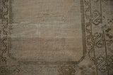 Vintage Oushak rug with distressed texture, localized foundation wear, and geometric bronze border.