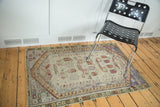Distressed vintage Oushak rug with faded saffron yellow, moss green, and royal purple.