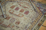Faded saffron, wine red, and purple tree-serpent motifs on a distressed vintage Oushak rug.
