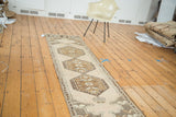 Angled view of Vintage Oushak runner, triple medallion design and meandering leaf border.